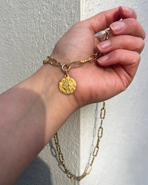 Mid century French St. Christopher pendant in 18kt yellow gold on chain held in hand showing scale and detail – Auric Vintage