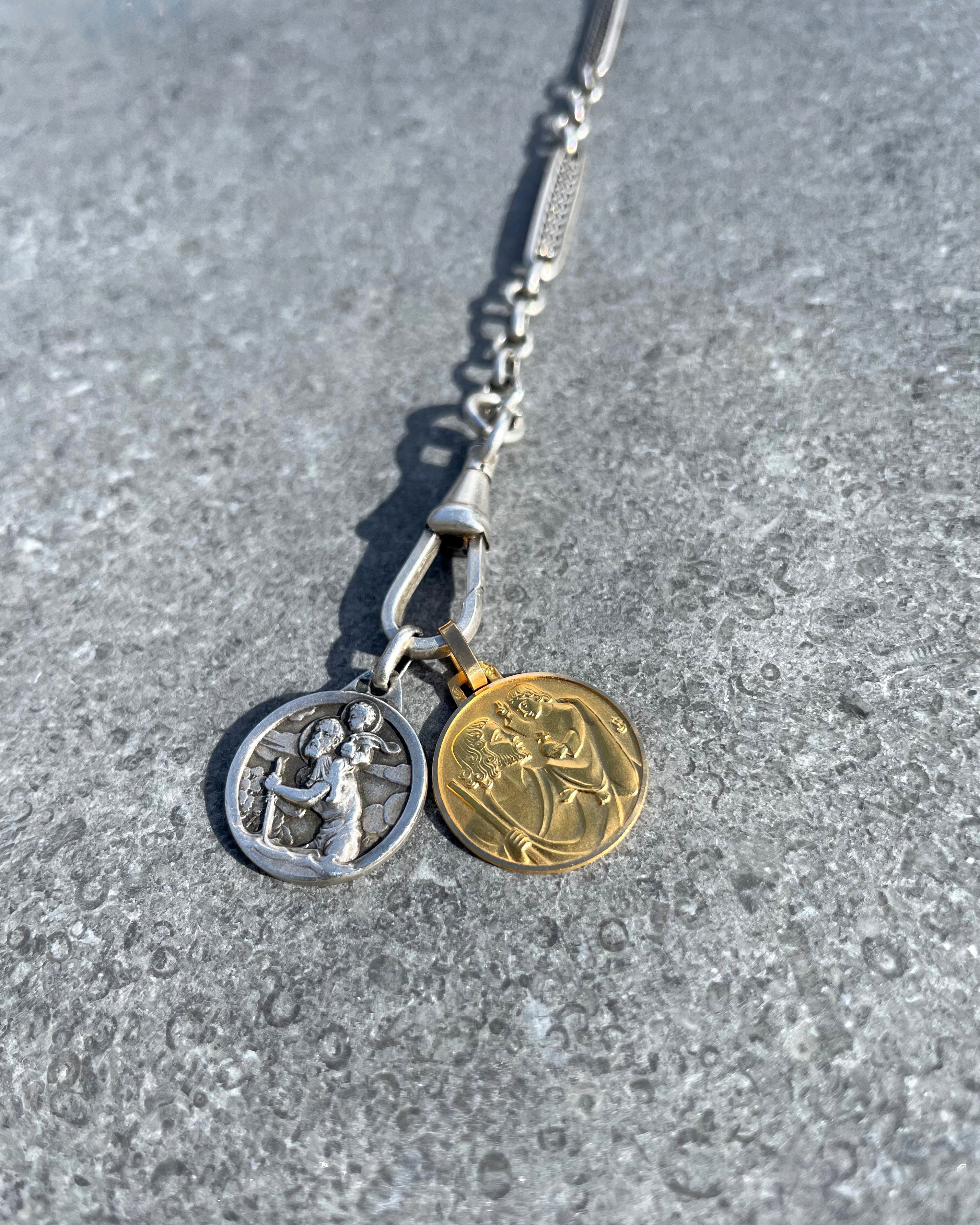 Vintage French mini St. Christopher medal in 18kt gold laid on chain showing scale and styling – Auric Vintage