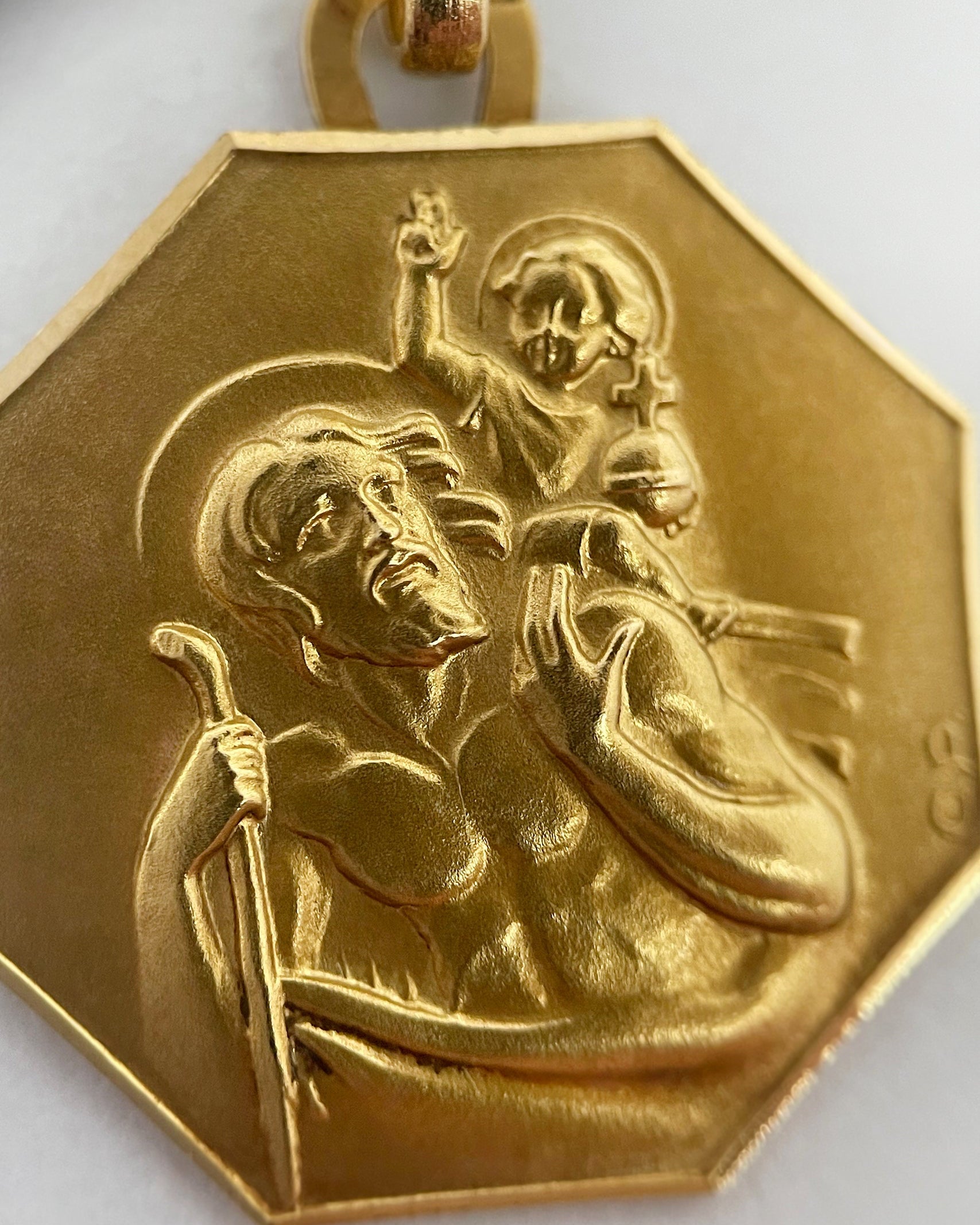 Close-up of 1950s French 18kt gold St. Christopher pendant showing Christ Child, staff and relief detail – Auric Vintage