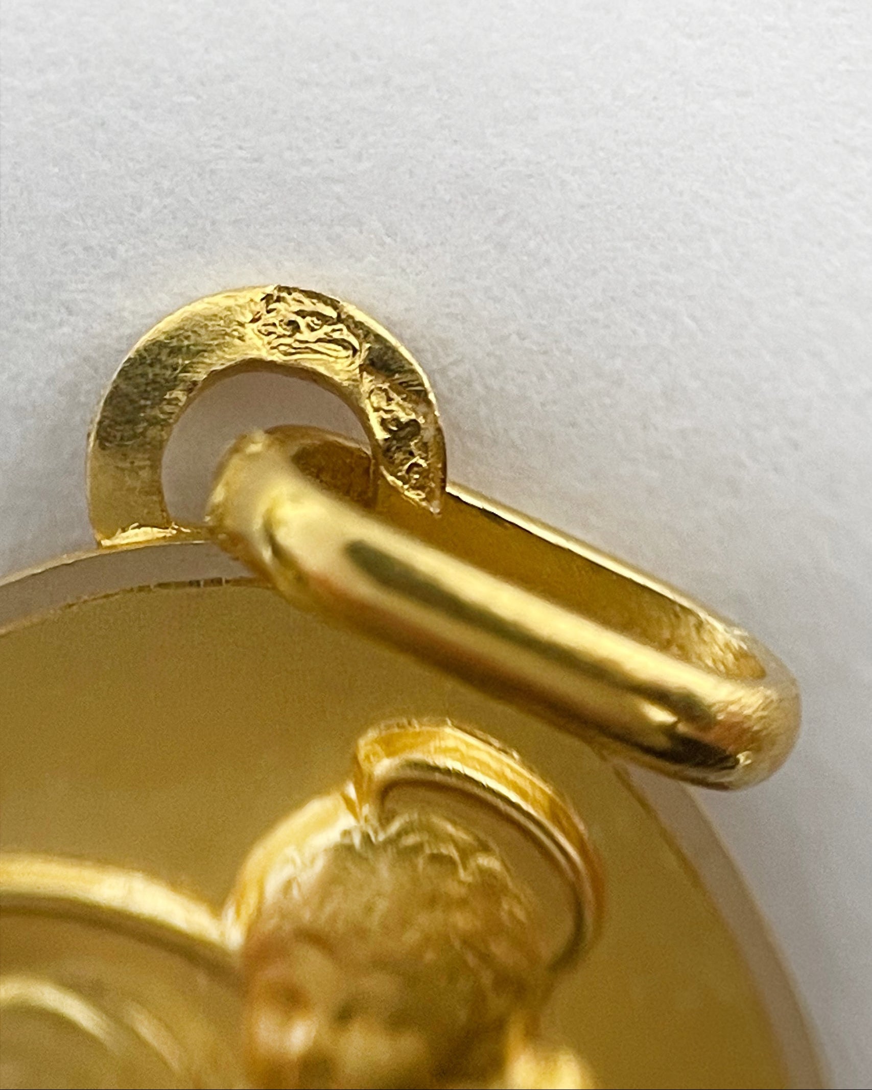 Close-up of 1950s French 18kt gold St. Christopher medal showing eagle’s head hallmark and maker’s mark – Auric Vintage