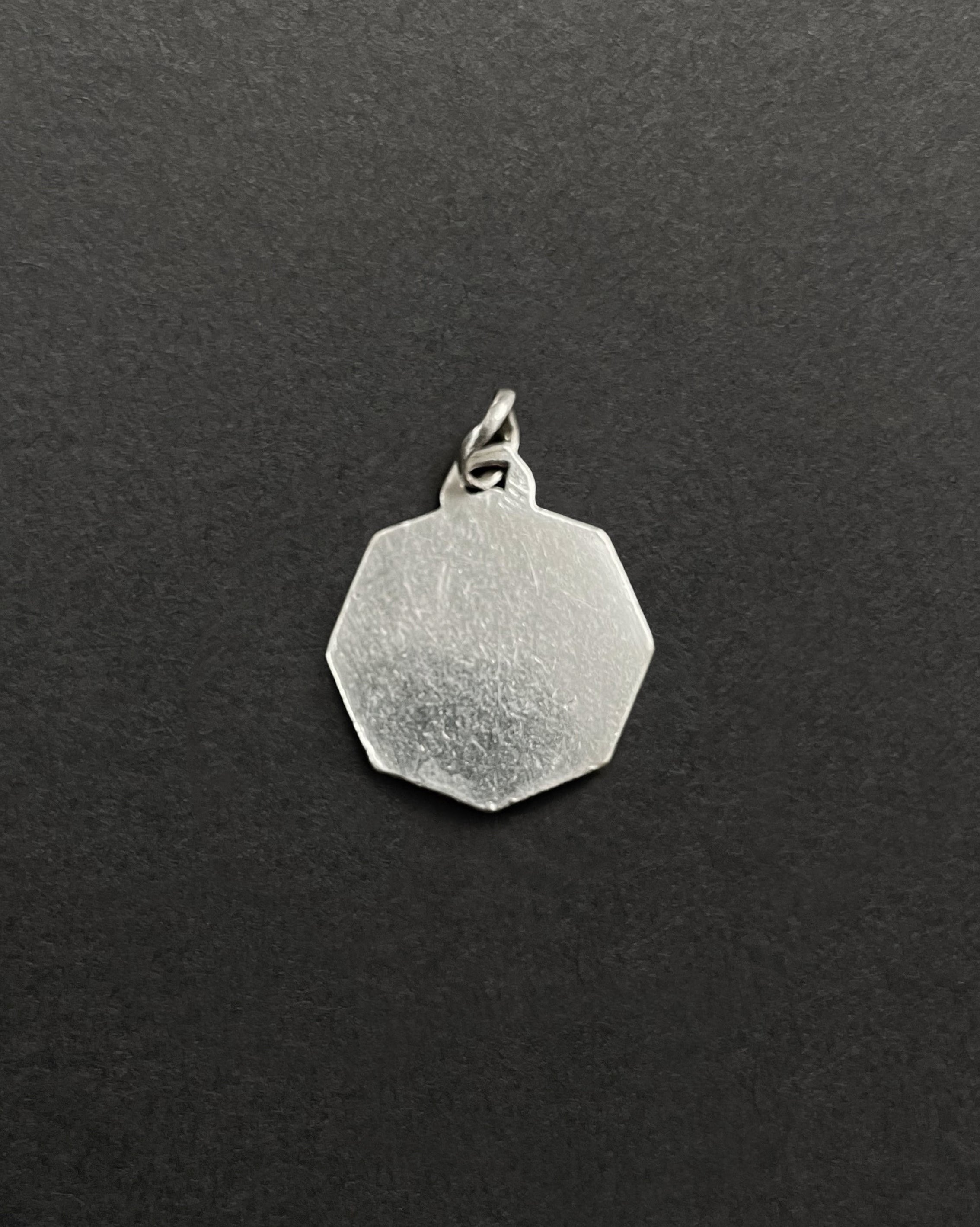 Reverse of vintage octagonal St. Christopher pendant in 800 silver showing smooth finish – Auric Vintage