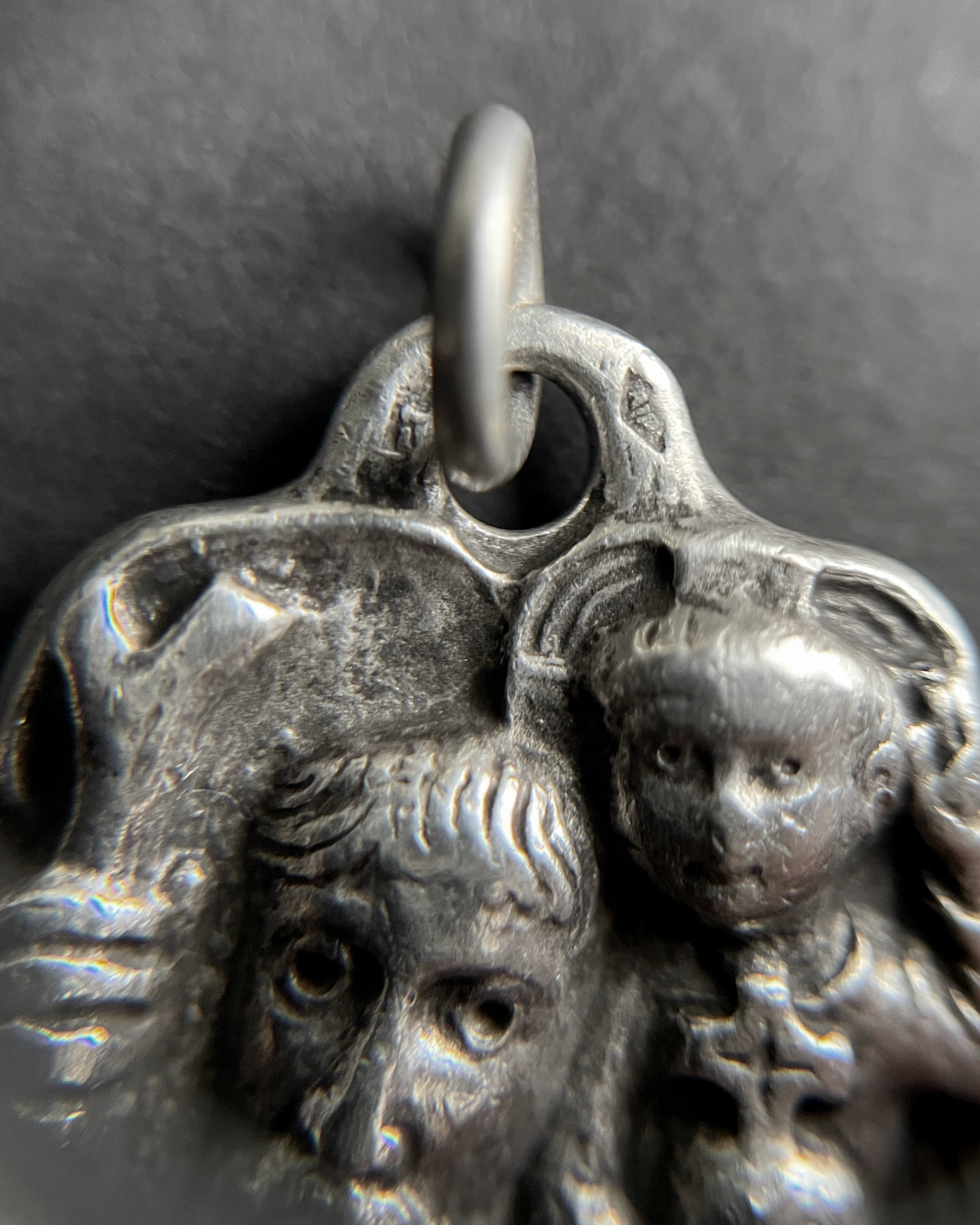 Close-up of 1960s French 800 silver St. Christopher pendant showing carved face detail – Auric Vintage