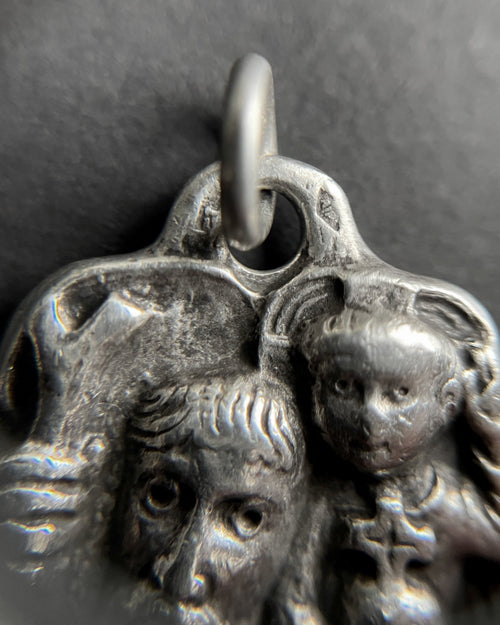 Close-up of 1960s French 800 silver St. Christopher pendant showing carved face detail – Auric Vintage