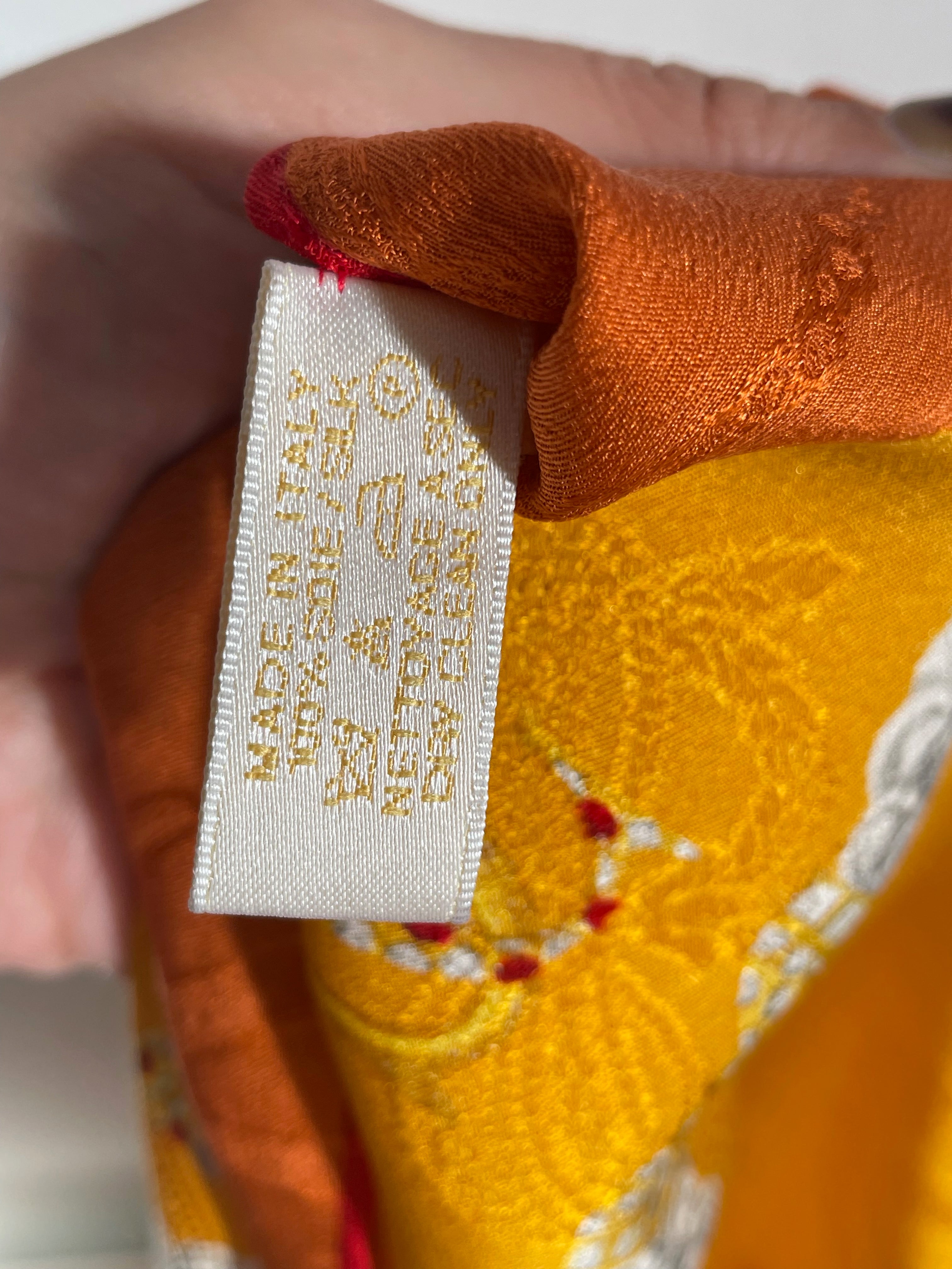 Reverse of Must de Cartier scarf tag showing Made in Italy and 100% silk detail – Auric Vintage
