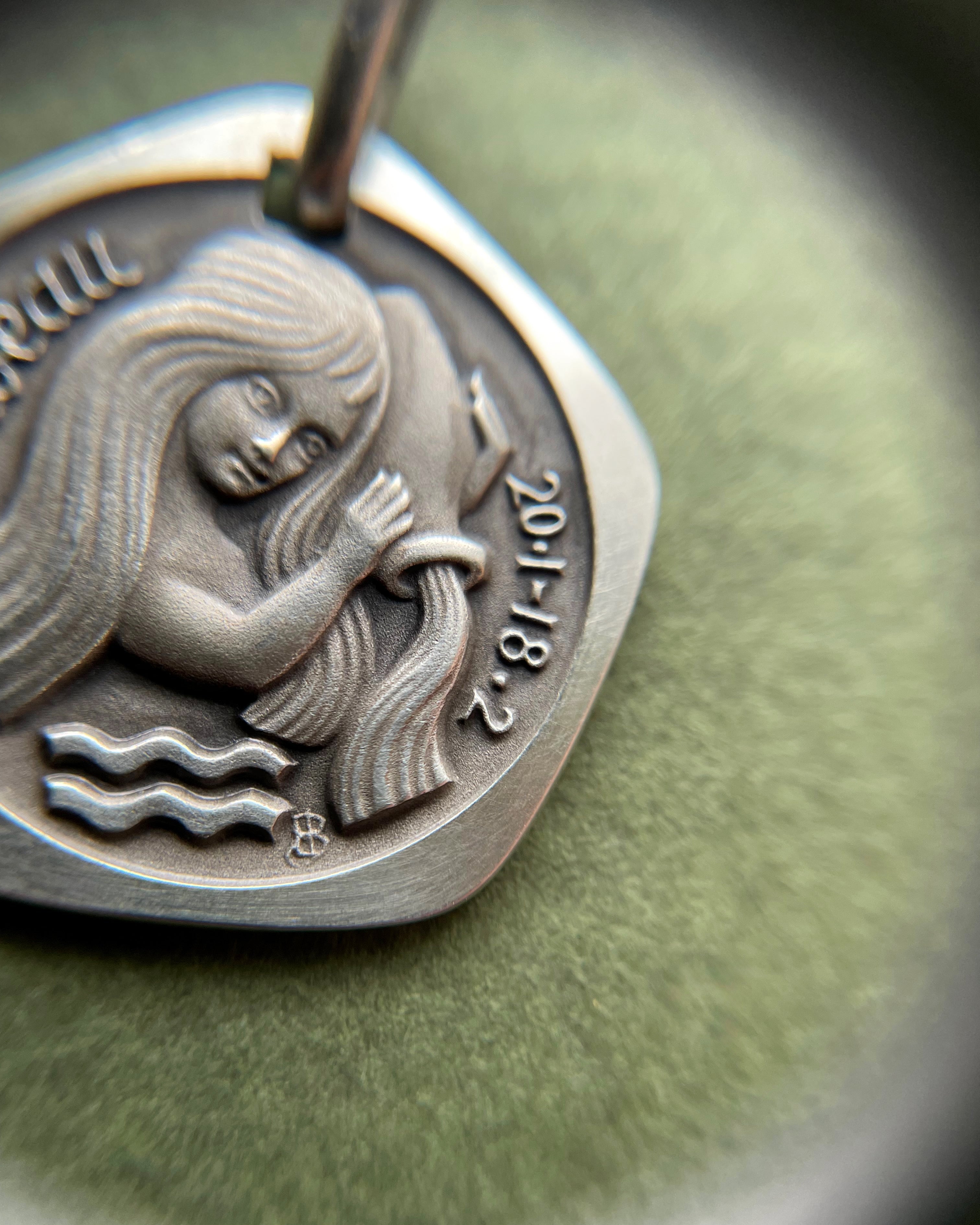 Close-up of 1970s French 800 silver Aquarius zodiac pendant showing figure detail – Auric Vintage