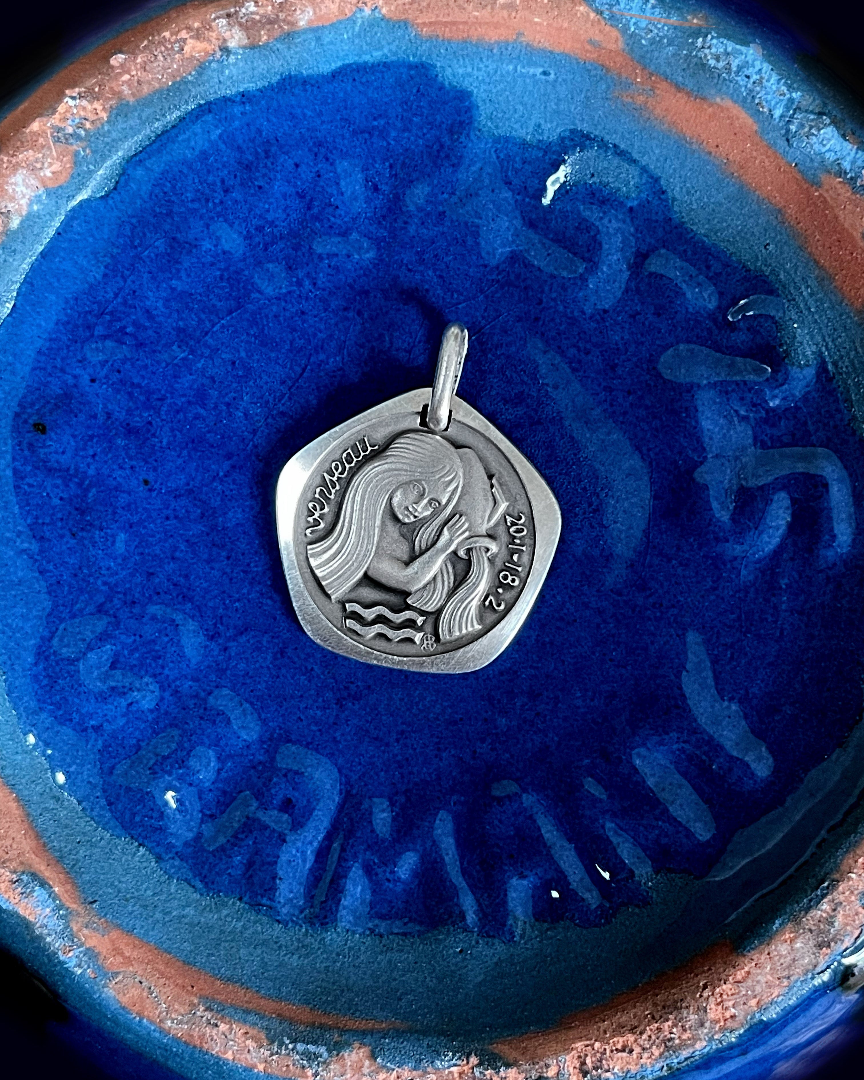 1970s French Aquarius zodiac pendant in 800 silver displayed on blue background – Auric Vintage