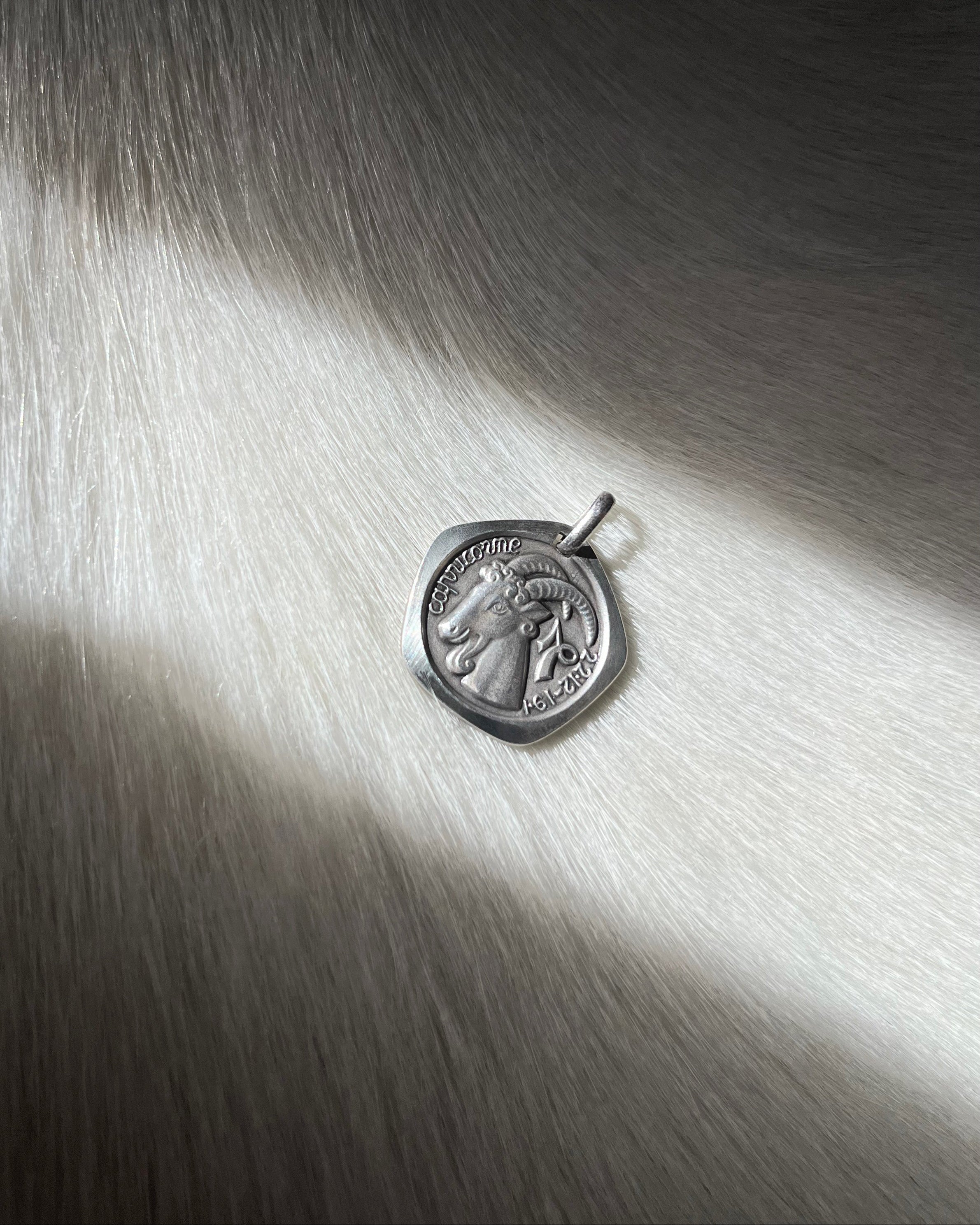 1970s French Capricorn zodiac pendant in 800 silver displayed on animal hide – Auric Vintage