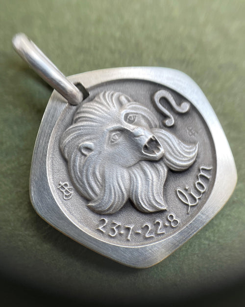 Close-up of 1970s French 800 silver Leo zodiac pendant showing lion head detail – Auric Vintage