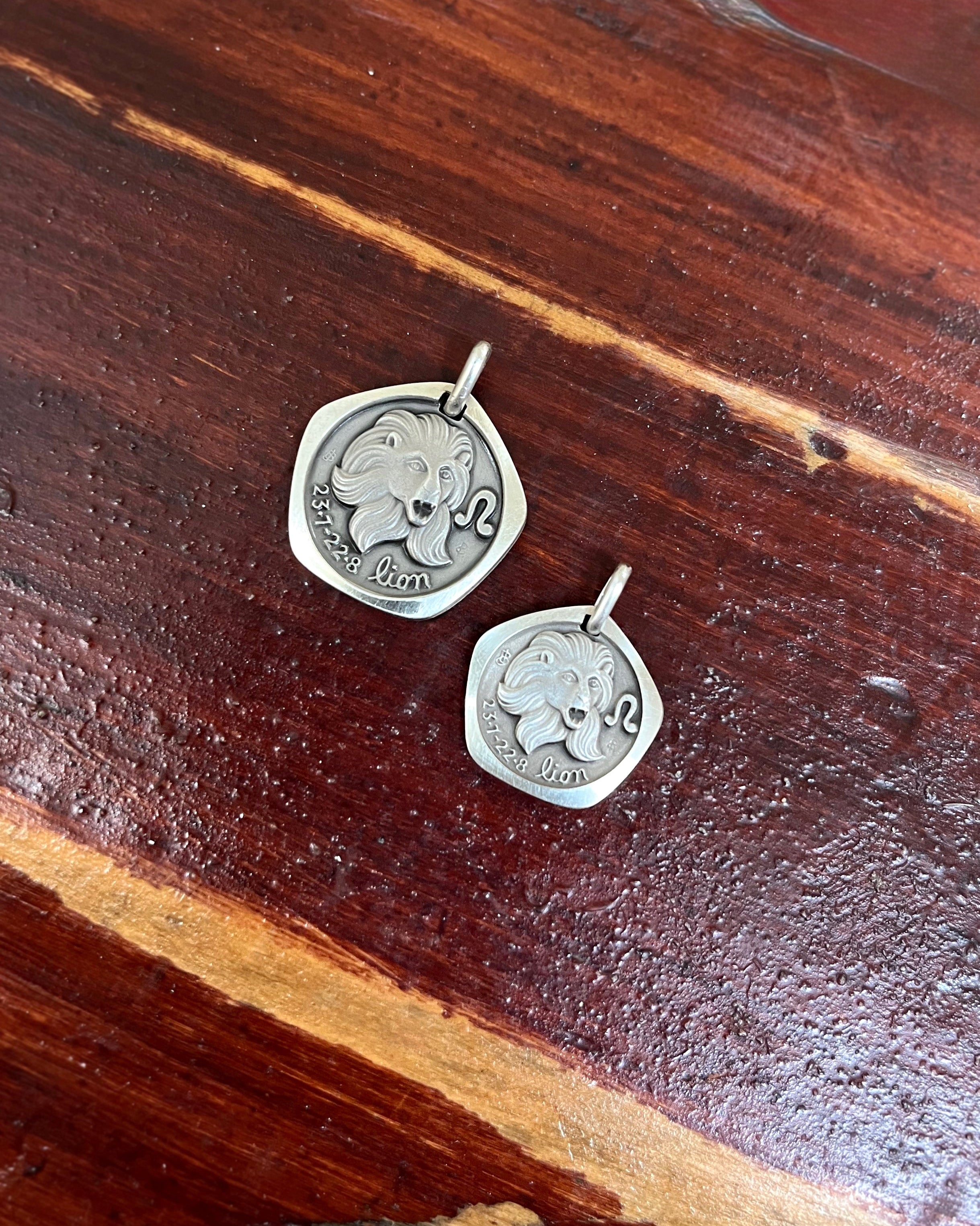 1970s French Leo zodiac mini pendant in 800 silver displayed on wooden background with size comparison – Auric Vintage