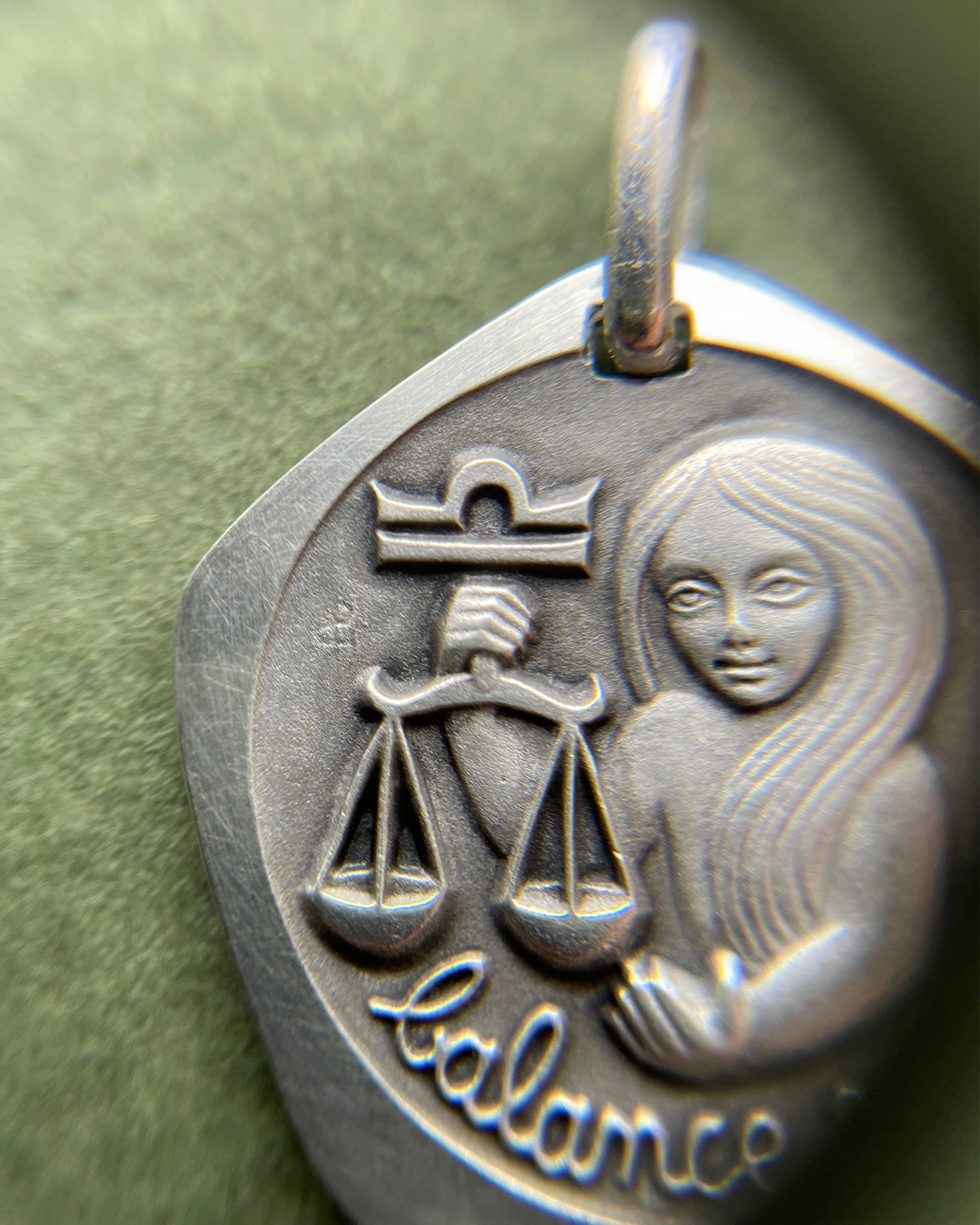 Close-up of 1970s French 800 silver Libra zodiac pendant showing figure detail – Auric Vintage