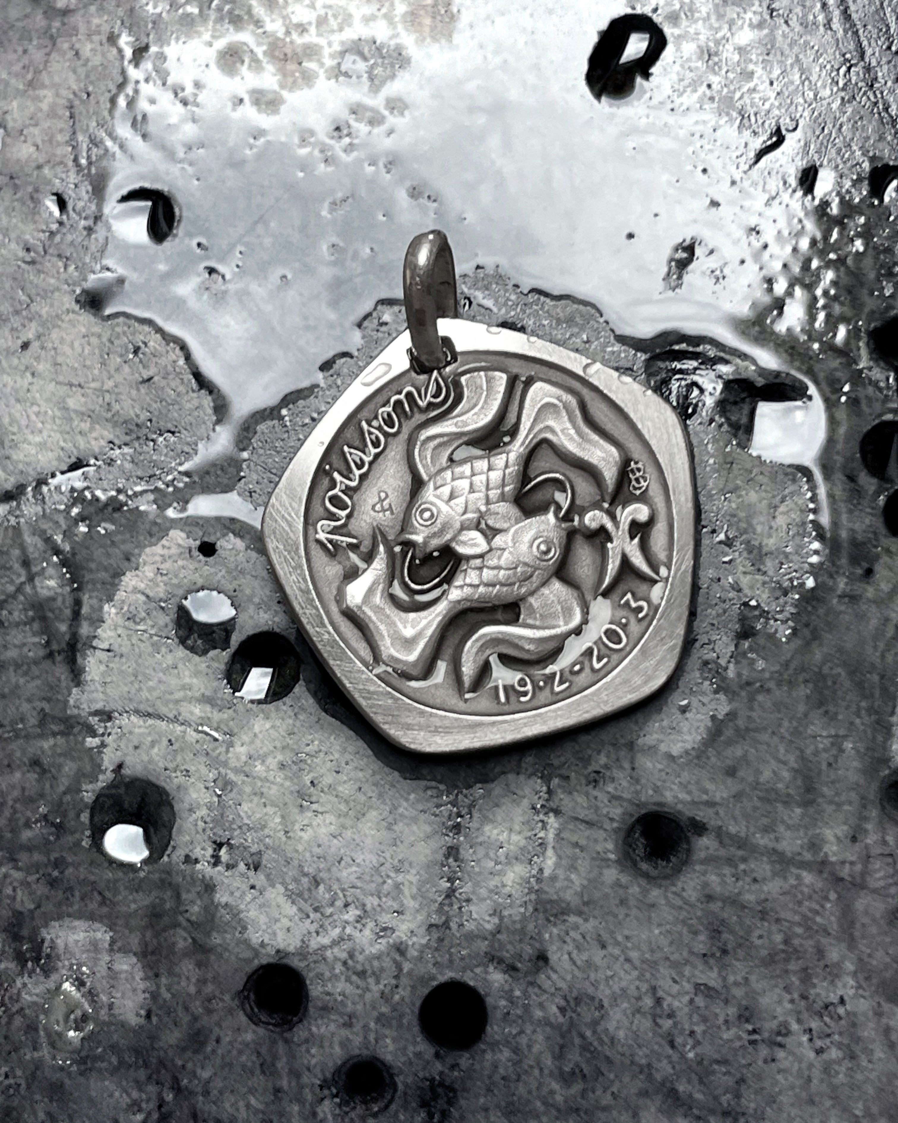 1970s French Pisces zodiac pendant in 800 silver displayed on wet concrete – Auric Vintage