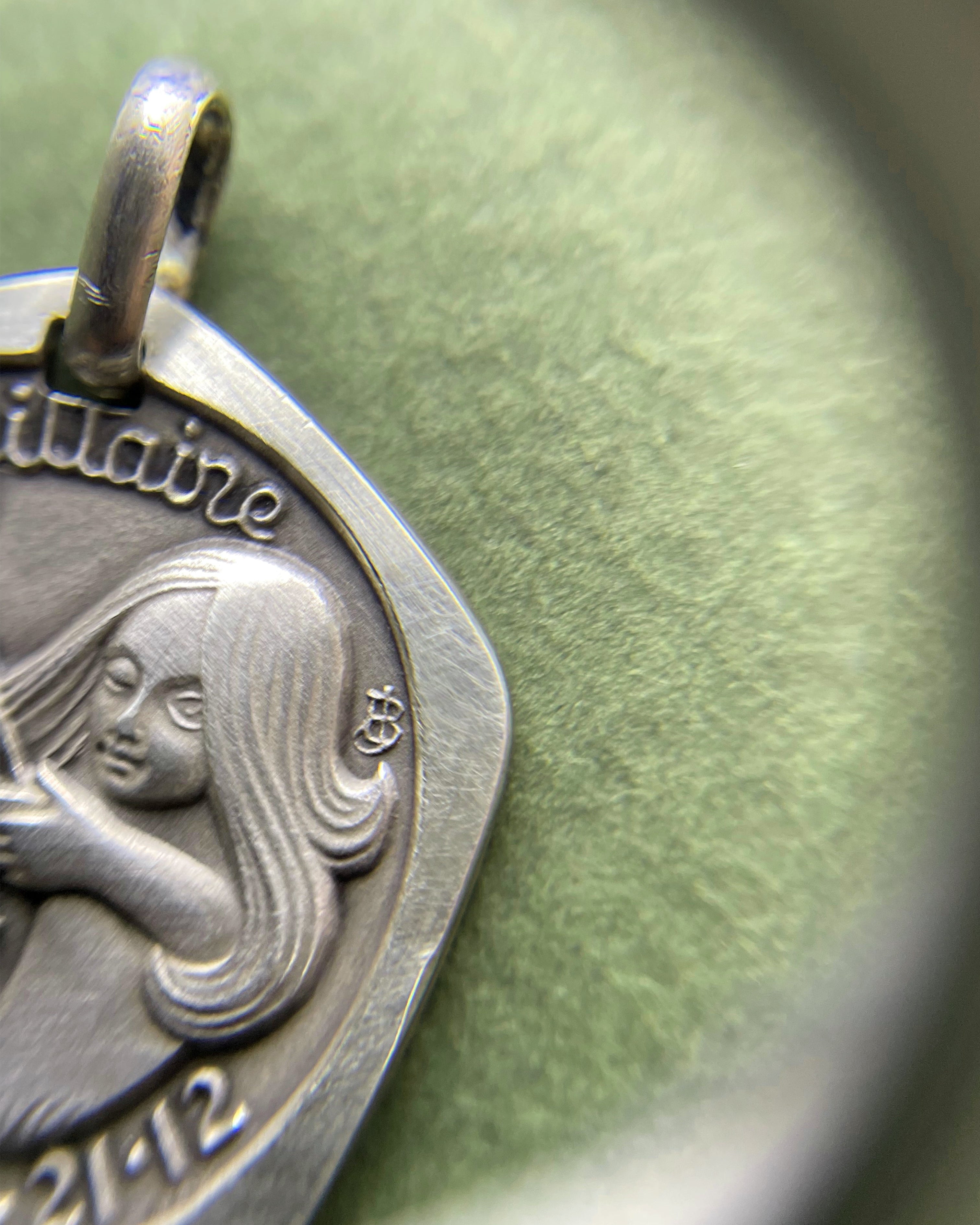 Close-up of 1970s French 800 silver Sagittarius zodiac pendant through jeweller’s loupe showing detail – Auric Vintage