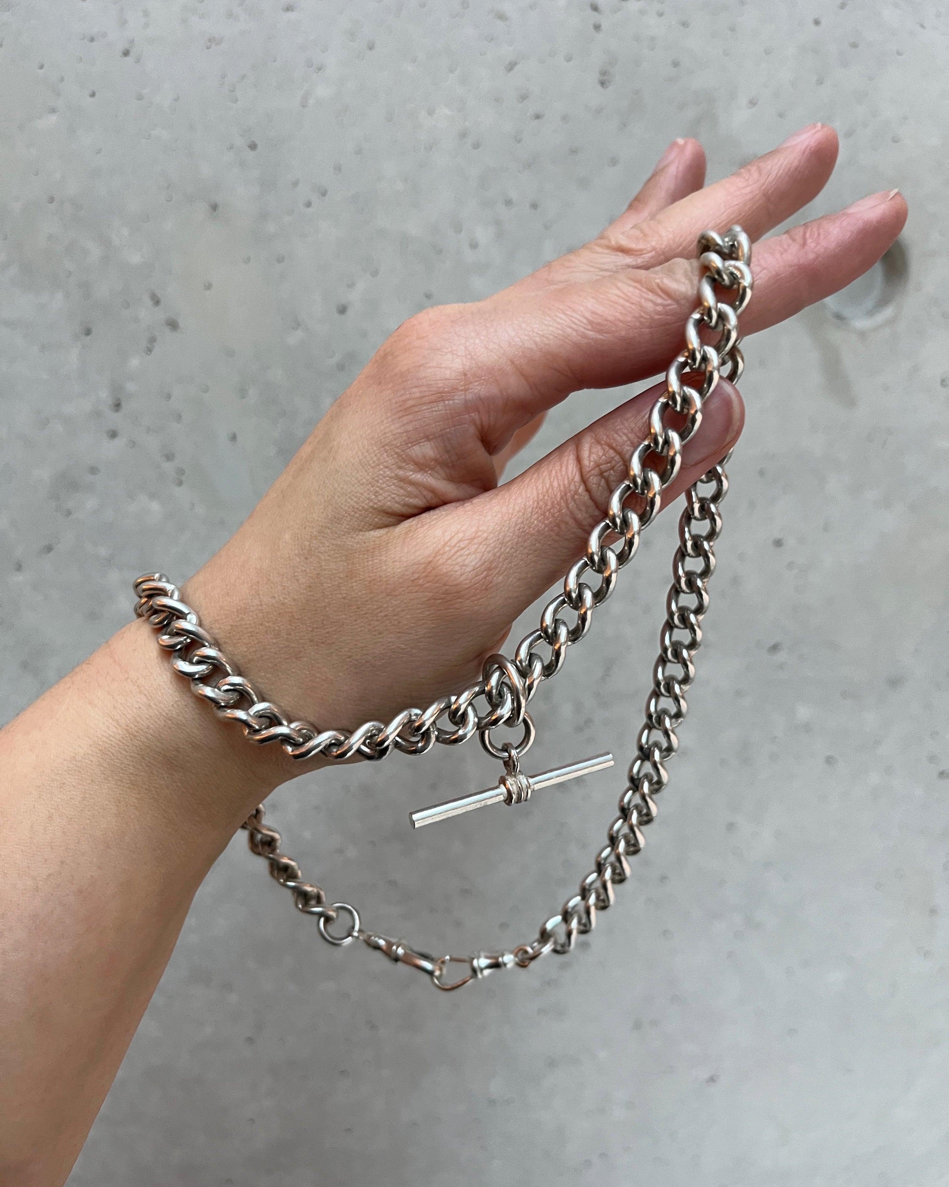 Vintage sterling silver curb link watch chain held in hand showing weight and scale – Auric Vintage