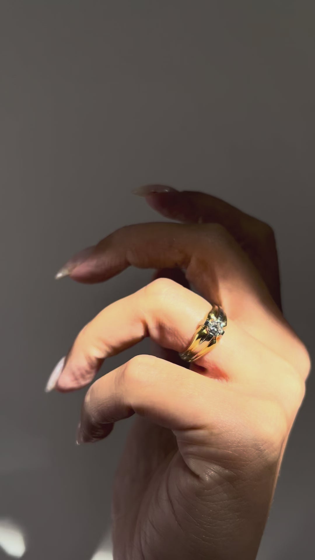 1990s vintage 18kt two-tone gold diamond solitaire engagement ring with a 0.20ct Old European cut diamond, shown on a hand to display the geometric compass setting and two-tone gold shoulders.