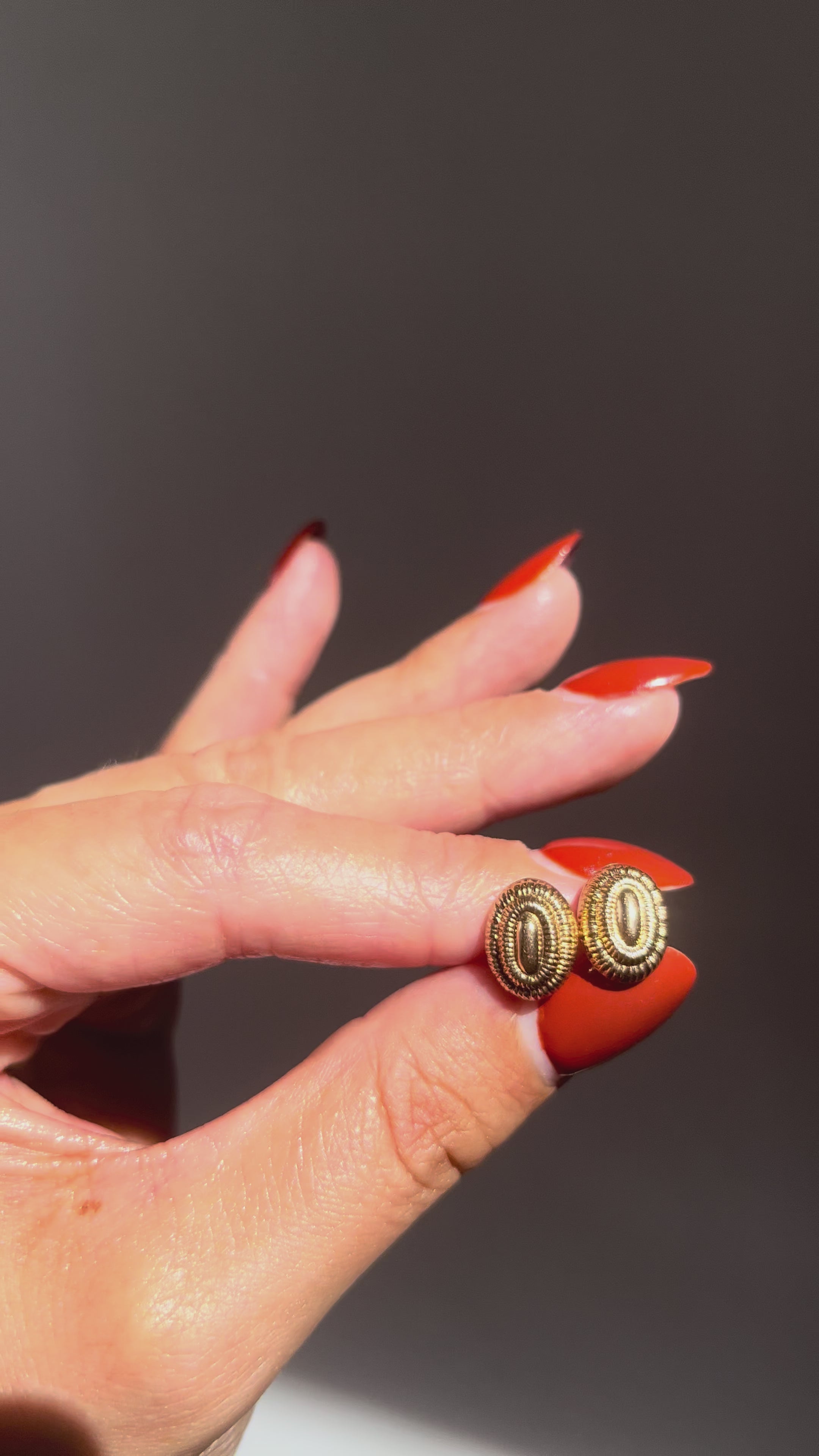 Seventies oval ribbed terraced stud earrings in 9kt yellow gold held in hand for scale – Auric Vintage