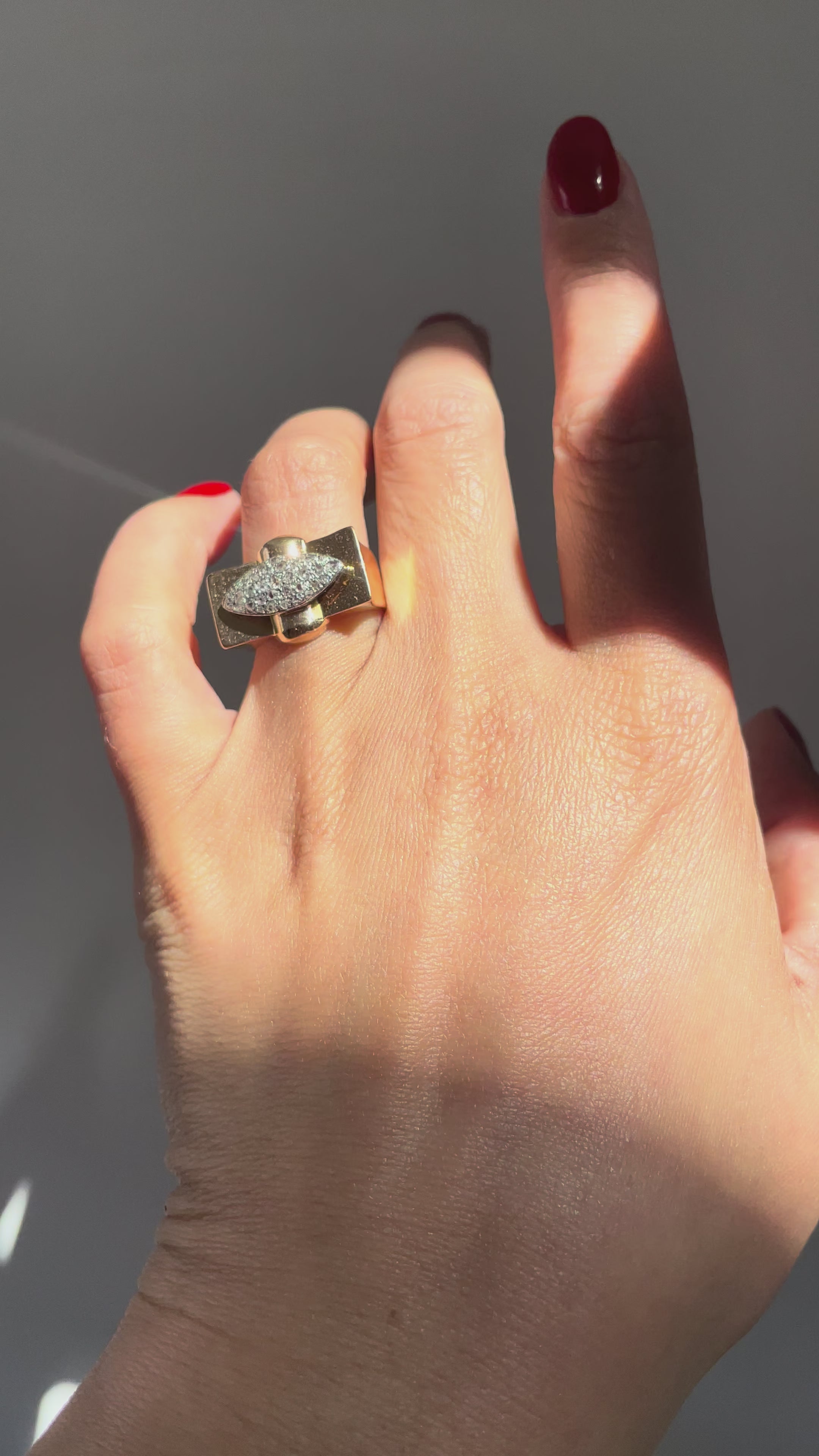 1940s vintage tank ring with rose cut diamonds in silver grain settings, shown worn on a hand, highlighting the angular chevron design and contrast between antique diamond cuts and polished metal.