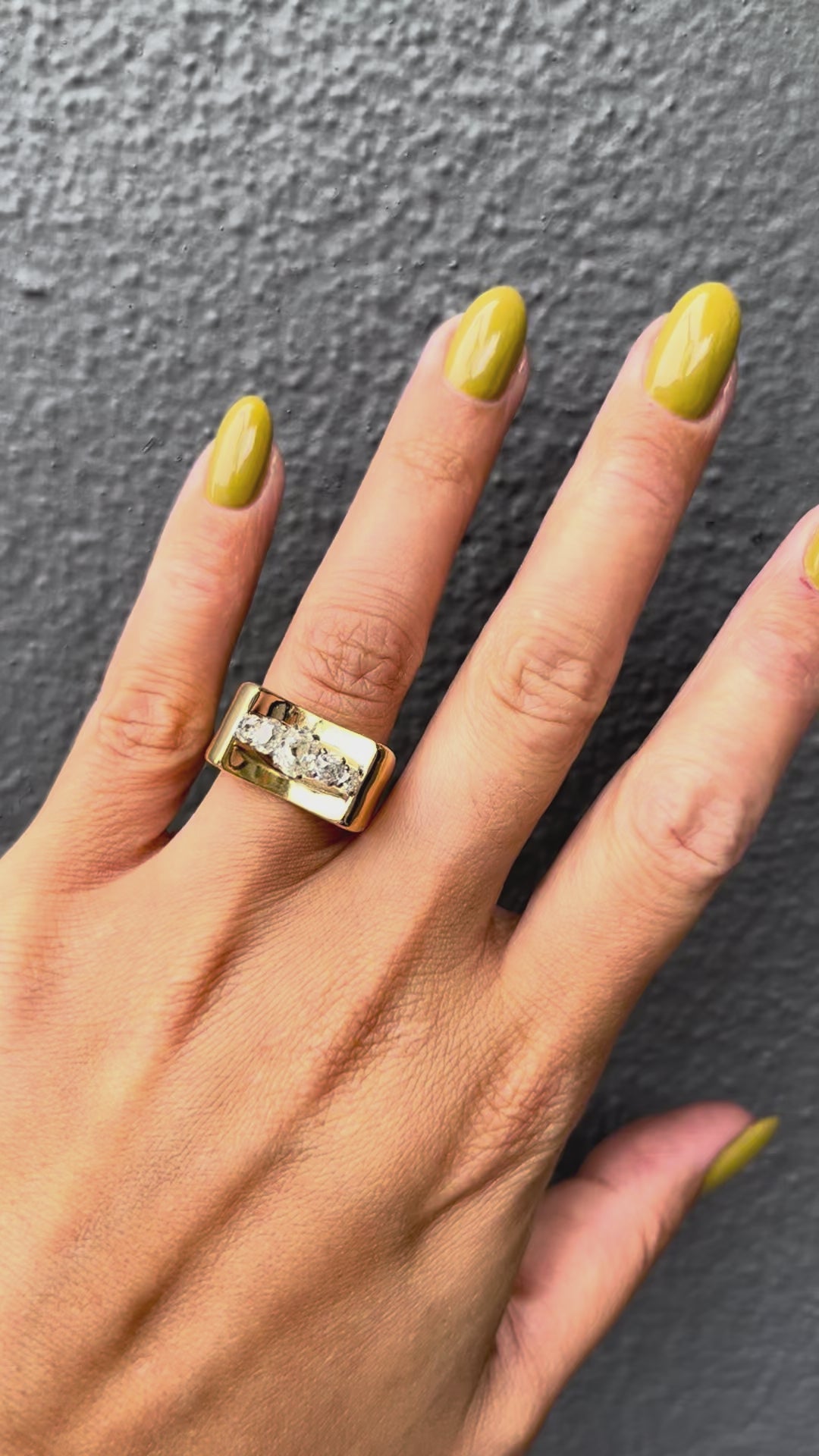 1940s vintage 18kt gold tank ring set with five graduating Old Mine cut diamonds, with an estimated total diamond weight of 0.80ct, shown worn on a hand.